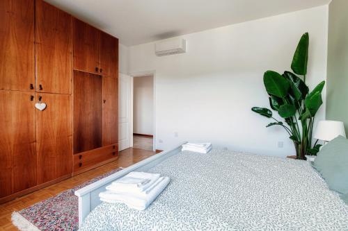 a bedroom with a bed and a wooden cabinet at Villa del Sole - Lake Como Garden in Cernobbio