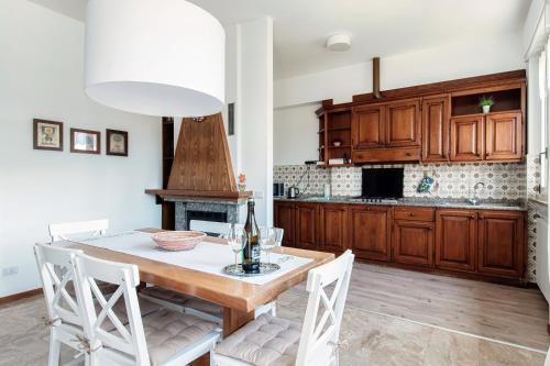 a kitchen with a table with chairs and a fireplace at Villa del Sole - Lake Como Garden in Cernobbio