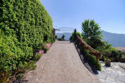 a stone path with bushes and a fence at Villa del Sole - Lake Como Garden in Cernobbio