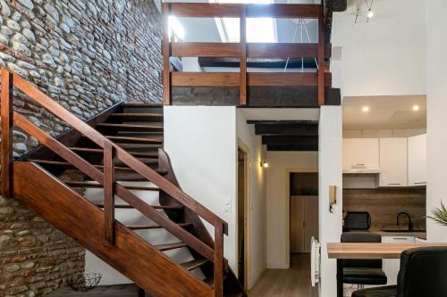 un escalier en mezzanine avec un mur en pierre dans l'établissement Atlas - Nexus, à Perpignan