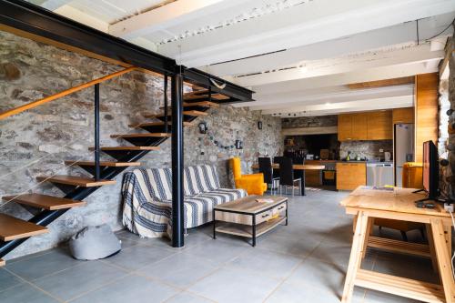 un soggiorno con una scala in un muro di pietra di GuestReady – Rustic Charm in Peaceful Madeira a Porto da Cruz