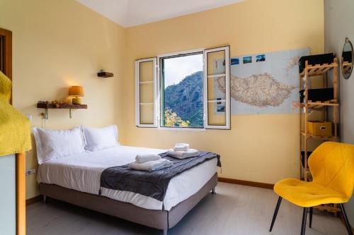 una camera con un letto, una finestra e una sedia di GuestReady – Rustic Charm in Peaceful Madeira a Porto da Cruz