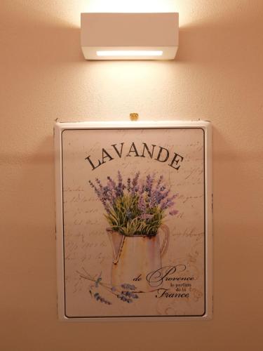 a sign hanging on a wall with a pot of flowers at Casa Melox in Lezzeno