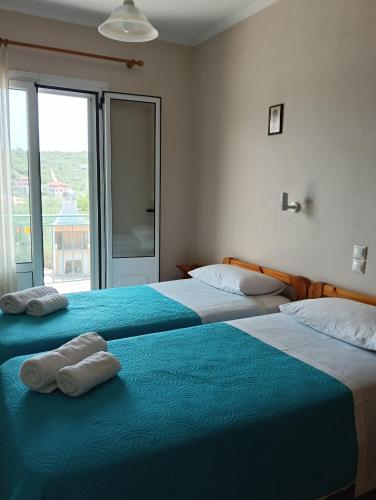 two beds sitting next to each other in a bedroom at Galini Studios in Sivota