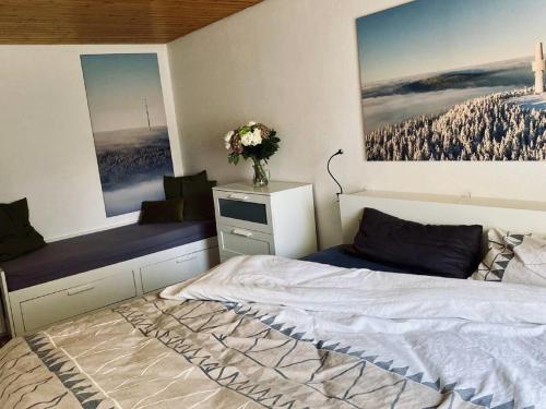 a bedroom with a bed and a vase of flowers at FICHTELRAUM Dein Raum im Fichtelgebirge in Gefrees