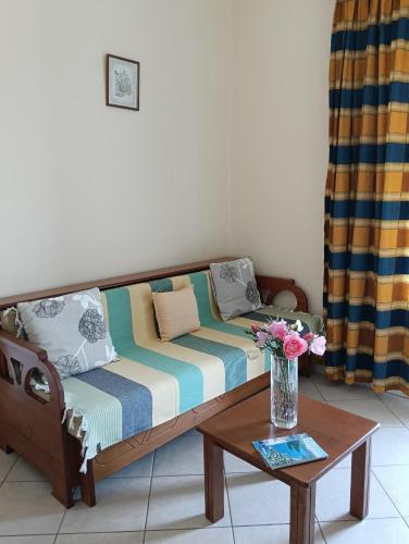 a couch sitting in a living room with a table at Galini Studios in Sivota