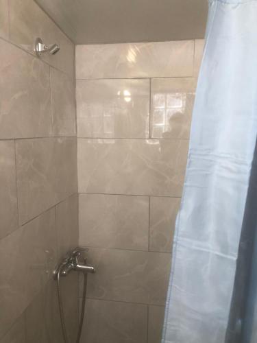 a shower with a shower curtain in a bathroom at Barreira Beachfront Room 5 in Kalamata