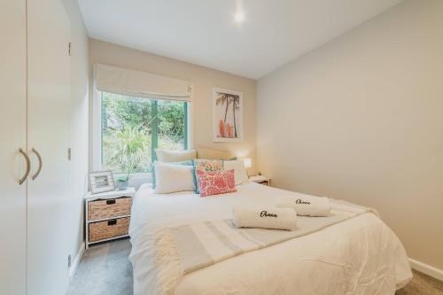 a bedroom with a large white bed with a window at Elevated Ocean View Oasis - 3BR 2 Bath Parking in Christchurch