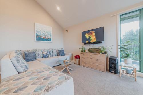 a living room with a bed and a tv at Elevated Ocean View Oasis - 3BR 2 Bath Parking in Christchurch