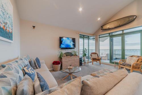 a living room with a couch and a tv at Elevated Ocean View Oasis - 3BR 2 Bath Parking in Christchurch