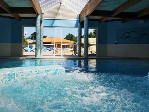une piscine avec de l'eau bleue dans un immeuble dans l'établissement Camping 4 étoiles - Parc aquatique - ccbahfb, à Saint-Hilaire-de-Riez