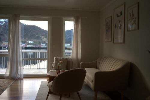 a living room with a couch and a table and a window at Seahouse Apartment with amazing views! in Ballstad