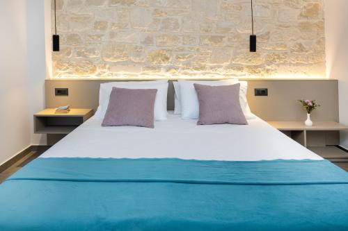 a bedroom with a large white bed with two pillows at Luxurious Villas Rocca Blanco 1 & 2 in Kounoupidhianá
