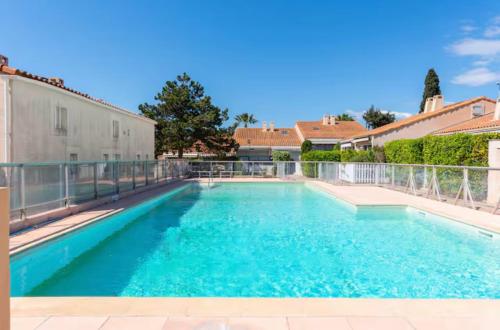 une piscine avec de l'eau bleue dans une maison dans l'établissement Villa club 4 personnes à Sanary sur Mer, piscine commune de mai à septembre, plage à 450m, à Sanary-sur-Mer