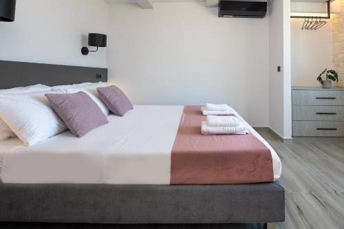 a bedroom with a large bed with white and purple pillows at Luxurious Villas Rocca Blanco 1 & 2 in Kounoupidhianá