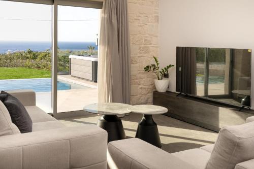 a living room with a couch and a table at Luxurious Villas Rocca Blanco 1 & 2 in Kounoupidhianá