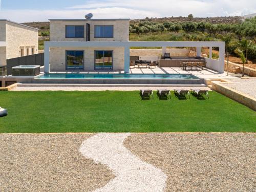 a house with a pool and a grass yard at Luxurious Villas Rocca Blanco 1 & 2 in Kounoupidhianá