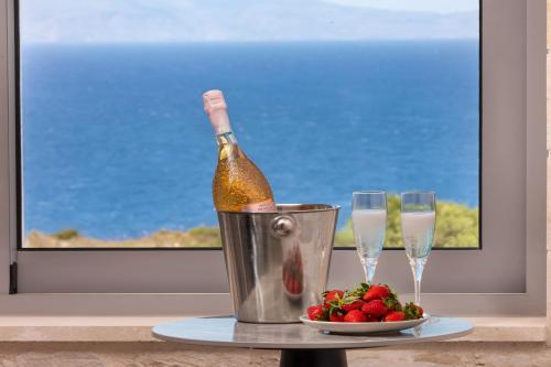 a bottle of champagne in a bucket next to two glasses at Luxurious Villas Rocca Blanco 1 & 2 in Kounoupidhianá