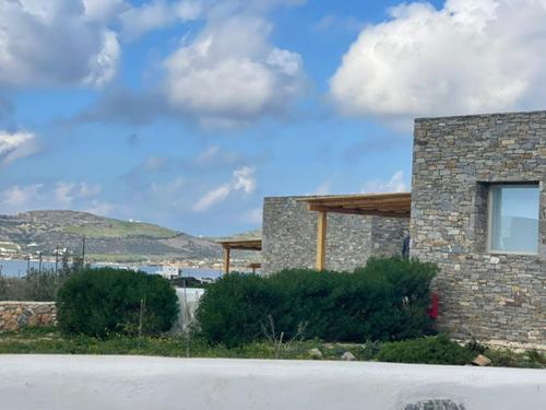 a stone building with a sky background and a road at CAMPO SUITES in Kampos Paros