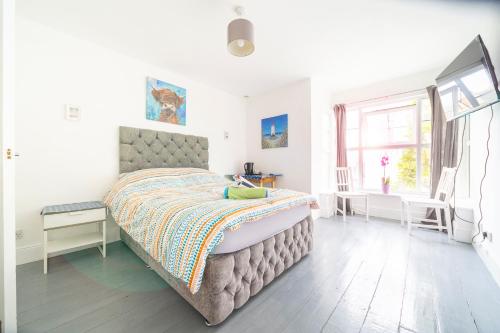 a bedroom with a large bed and a window at Palace Guesthouse in Newquay