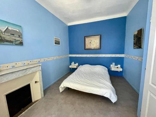 une chambre bleue avec un lit et une cheminée dans l'établissement Maison Familiale - Plage privée, à Carqueiranne