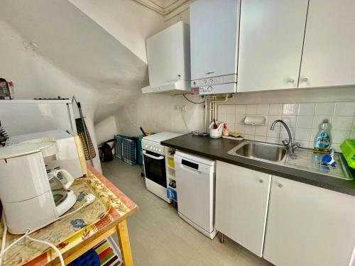 une cuisine avec des armoires blanches et un évier dans l'établissement Maison Familiale - Plage privée, à Carqueiranne