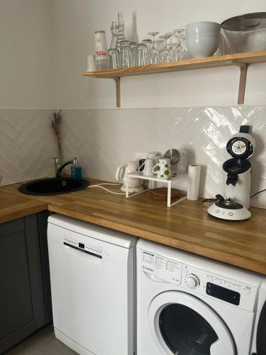 - un comptoir de cuisine avec un lave-linge et un évier dans l'établissement Duplex avec cour intérieure, à Bourges