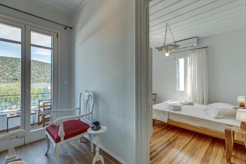 a white bedroom with a bed and a window at Andy Port House with Seaview by Goutos Properties in Ermioni