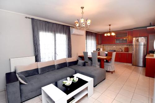 a living room and kitchen with a couch and a table at Epanomi Apartments in Epanomi
