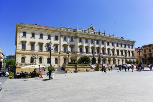 a large building with people walking in front of it at B&B Le Finestre Su Via Cavour in Sassari
