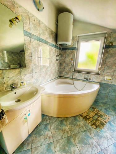 a bathroom with a tub and a sink and a mirror at Appartaments Lion in Marinići