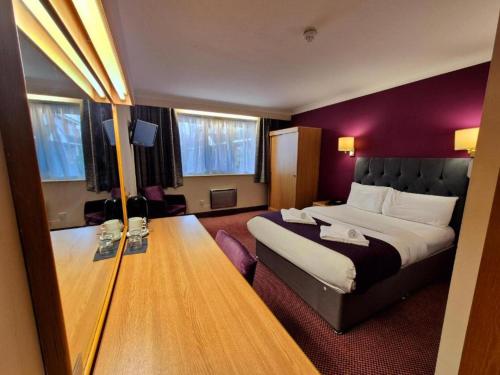 a bedroom with a large bed and a purple wall at Boston Supreme Hotel in Boston
