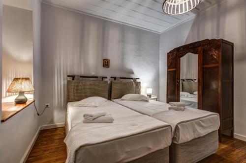 a bedroom with a large bed and a mirror at Andy Port House with Seaview by Goutos Properties in Ermioni