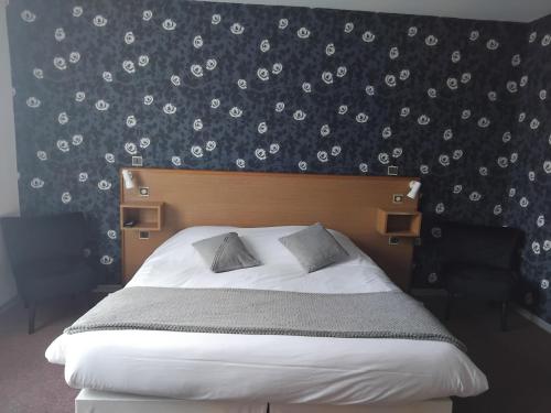 a bedroom with a bed with a black and white wallpaper at Hôtel de Tessé in Bagnoles de l'Orne