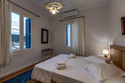 a white bedroom with two beds and a window at Andy Port House with Seaview by Goutos Properties in Ermioni