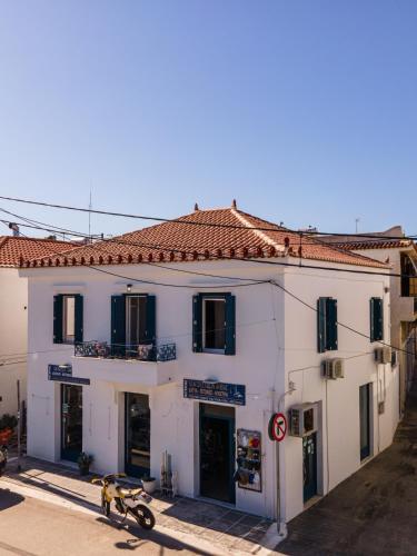 a white building with a motorcycle parked in front of it at Andy Port House with Seaview by Goutos Properties in Ermioni