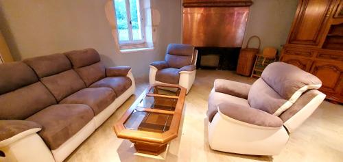 a living room with couches and chairs and a table at La Grande Vesvre in Gigny