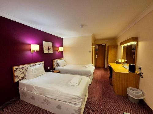 a hotel room with two beds and a desk at Boston Supreme Hotel in Boston