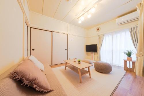 a living room with a couch and a table at Full House Rent in Tokyo, Ghibli, Sakura, Shinjuku 1H in Higashi-murayama