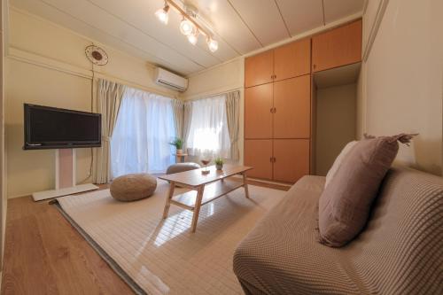 a living room with a couch and a table at Full House Rent in Tokyo, Ghibli, Sakura, Shinjuku 1H in Higashi-murayama