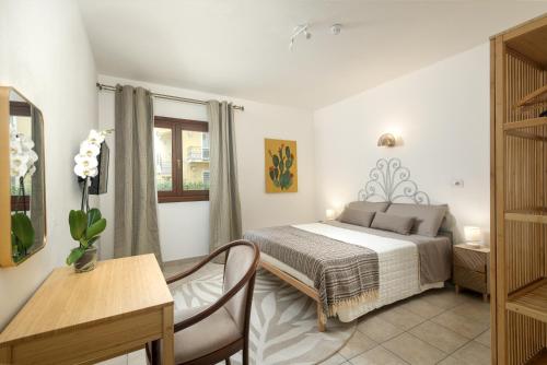 a bedroom with a bed and a table and a desk at Hotel Moderno in Olbia