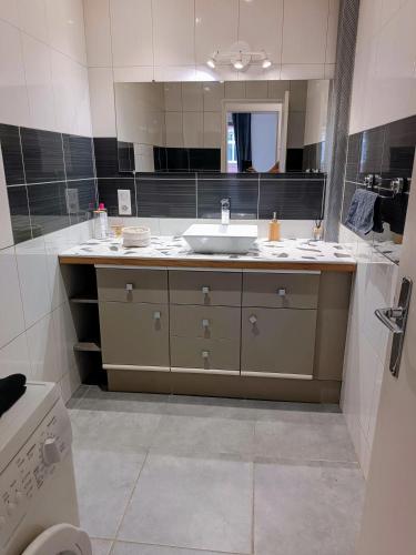 une salle de bain avec un lavabo et un miroir dans l'établissement Les trois Frontières, à Saint-Louis