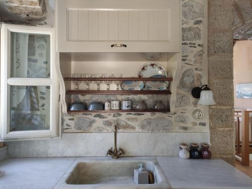 a kitchen with a sink and a window at Stone house 1883 Kymi with pool in Enoría