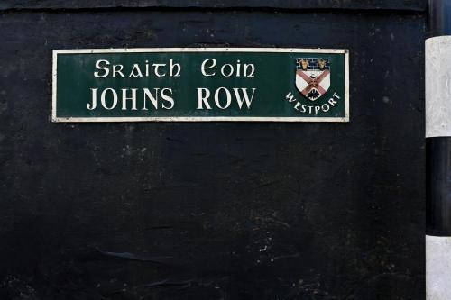a green street sign on the side of a building at The Row in Westport Town in Westport