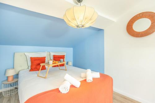 a bedroom with a bed with orange and blue at Le Travi - Studio climatisé au centre de Bergerac in Bergerac
