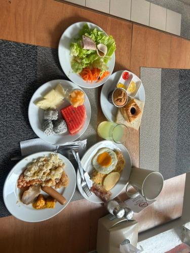 Nirvana Rooms near Mall Road في شيملا: مجموعة من أطباق الطعام على طاولة