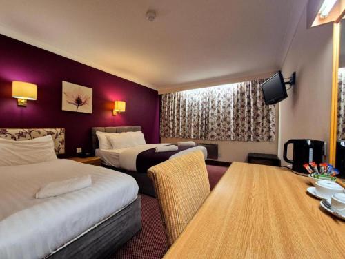a hotel room with two beds and a table at Boston Supreme Hotel in Boston