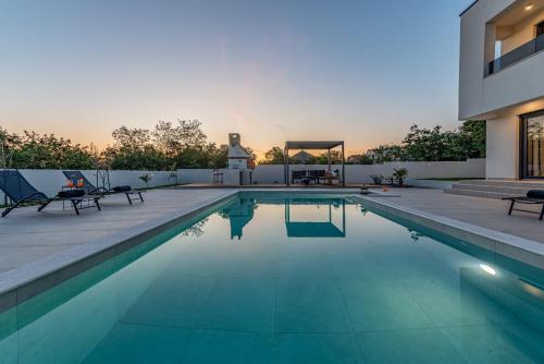 a swimming pool in the backyard of a house at Villa Roma Murvica ZadarVillas in Murvica