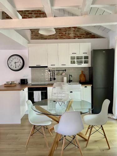 a kitchen with a glass table and white chairs at Plane Tree House in Próti