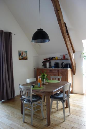 une table à manger avec des chaises et une lumière noire dans l'établissement Le Nourhoët havre de Paix à l'Orée de Brocéliande, à Campénéac